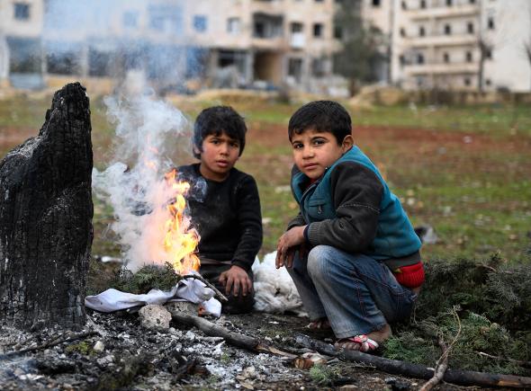 ACNUR NIOS REFUGIADOS SIRIOS SE CALIENTAN EN UNA HOGUERA
